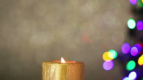 Candle with christmas tree lights in background Video stock 30960941
