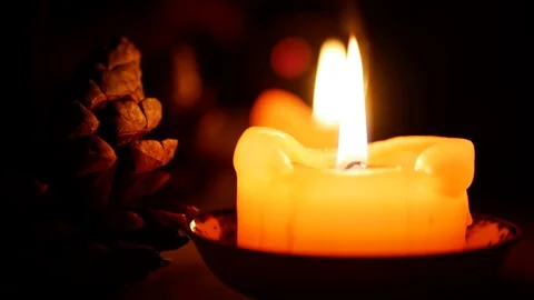 Candle in dark with reflection and a cone christmas decoration Vidéo 102980414