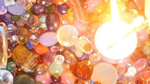 Candle fire set up on precious gemstones surface top view zoom Stock Footage 76120197