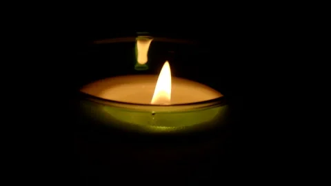 A candle fire stands at night in dark on a black background and revolves Stock Footage 152471973