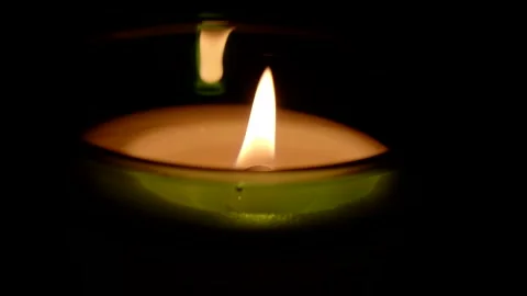 A candle fire stands at night in dark on a black background and revolves Stock Footage 152472046