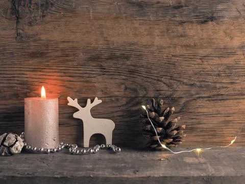 Candle of the first Advent burns, pine cones and Christmas decoration on wood Stock Photos