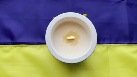A candle on the flag of Ukraine Stock Footage 245562152