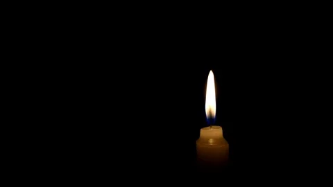 Candle flame on black background. The concept of mourning, grief or sorrow. 動画素材 101696402