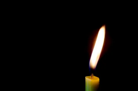 Candle flame on a black background. Stock Photos