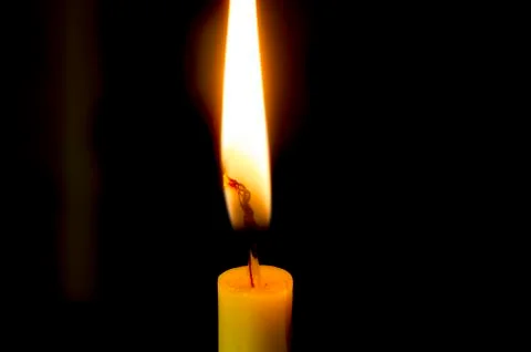 Candle flame on a black background. Stock Photos