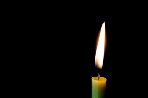 Candle flame on a black background. Stock Photos