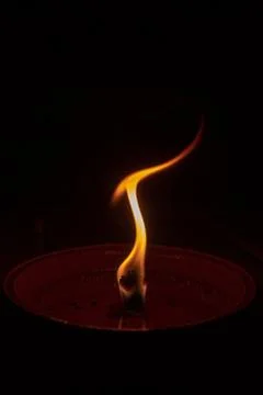 Candle flame close up on dark background, interesting flame figure Stock Photos