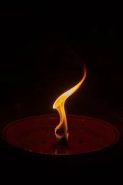 Candle flame close up on dark background, interesting flame figure Stock Photos
