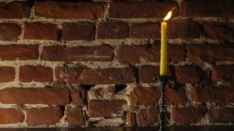 Candle flame close-up on a light red wall background. Melted Wax Candle light Stock Photos