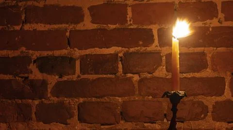 Candle flame close-up on a red wall background. Melted Wax Candle light borde Foto stock