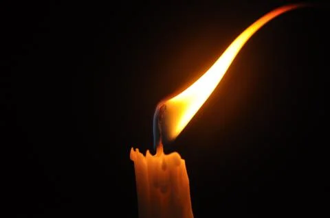 Candle with flame in dark background Stock Photos