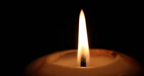 Candle flame glowing on the black background 4K Stock Footage 98761884