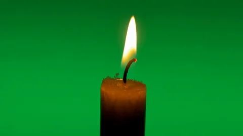 Candle flame on green background Stock Footage 122863573