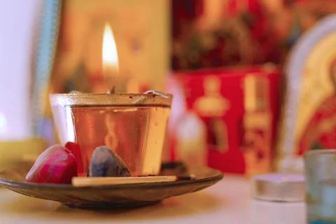 Candle with flame placed on a tray with colored stones and incense in a dec.. Stock Photos