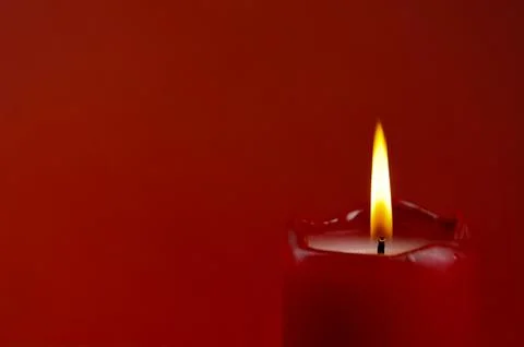 Candle flame on red background Stock Photos
