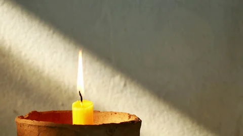 Candle flame on sunrise drop shadow old concrete wall. Stock Footage 150840796