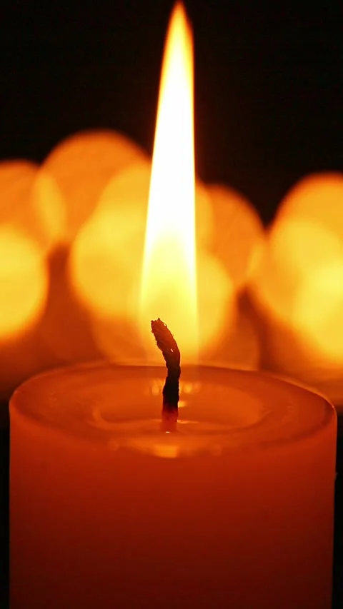 Candle flame with warm bokeh shifting softly in dark scene Stock Footage 324006472