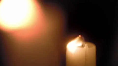 The candle flame wavers in the wind against a dark background and goes out in Stock Footage 217690089