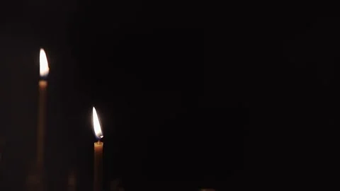 Candle flames flicker gently in a dimly lit space Stock Footage 326067839