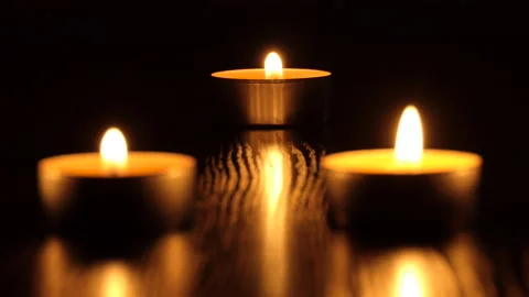The candle flickers in the dark A white round candle burns on a dark background Stock Footage 172309758