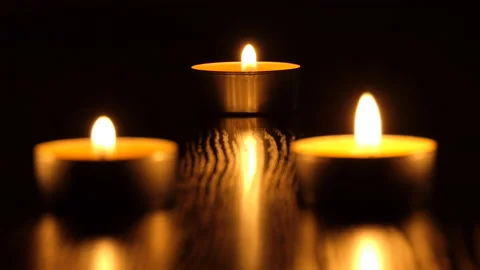 The candle flickers in the dark A white round candle burns on a dark background Stock Footage 172309888