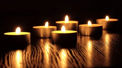 The candle flickers in the dark A white round candle burns on a dark background Stock Footage 172310236