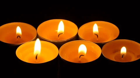 The candle flickers in the dark A white round candle burns on a dark background Stock Footage 172311115