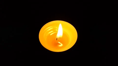 The candle flickers in the dark A white round candle burns on a dark background Stock Footage 172311767
