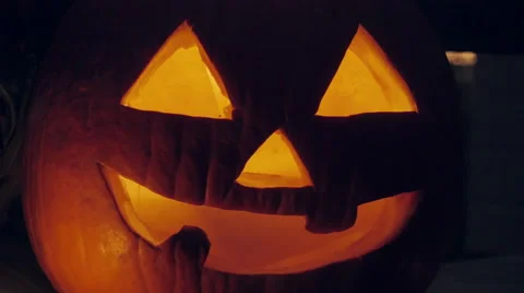 A Candle Flickers inside a Spooky Jack o'lantern Pumpkin Stock Footage 68933161