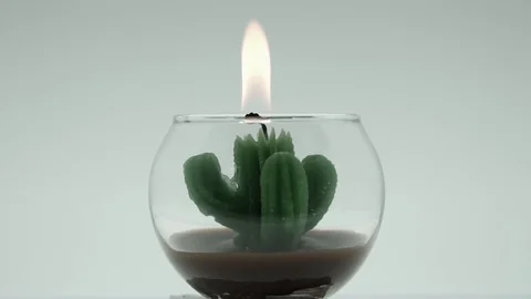 Candle in the form of a cactus. flame blows man Stock Footage 106677060