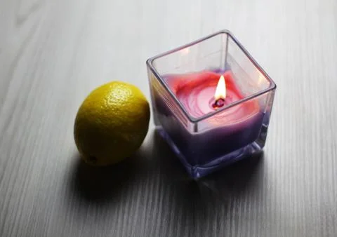Candle with a fresh lemon on the light background Stock Photos