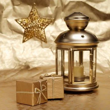 Candle, gifts and star on a gold background Stock Photos