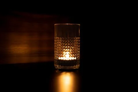 Candle in a glass. Rays of light are refracted through the walls of the glass Stock Photos