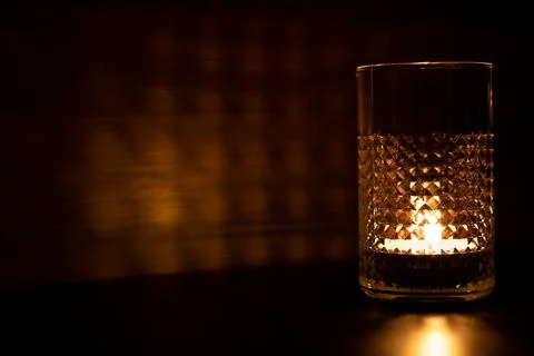 Candle in a glass. Rays of light are refracted through the walls of the glass Stock Photos