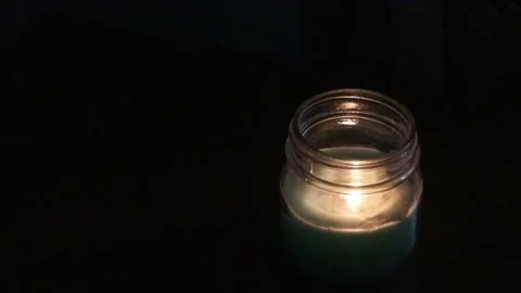 Candle in glass vase in a dark room Stock Footage