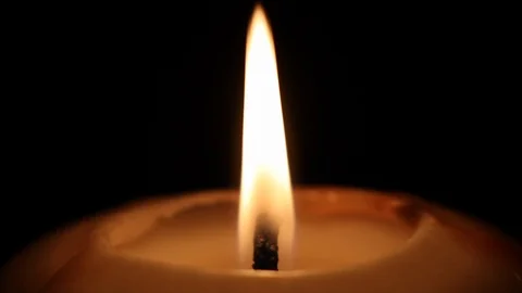 Candle glowing flame close up on black background 库存影片 98761920