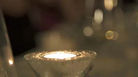 Candle Glowing In Front Of Gleamy Flared Background Stock Footage 49499732