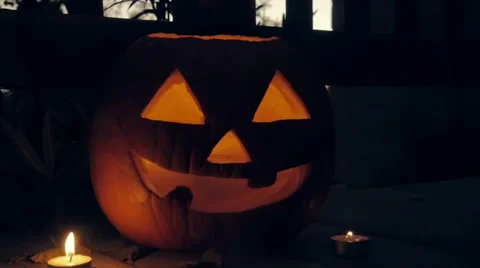 A Candle Glows inside a Spooky Jack o'lantern Pumpkin Stock Footage 68931568