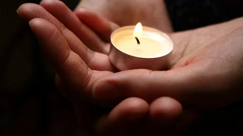 Candle in hands. Close up. Background of candle lighting in woman's hands. Stock Footage 101928391