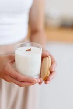 Candle in Hands of Light Background close-up. Place for Label. Minimalist Hom Stock Photos