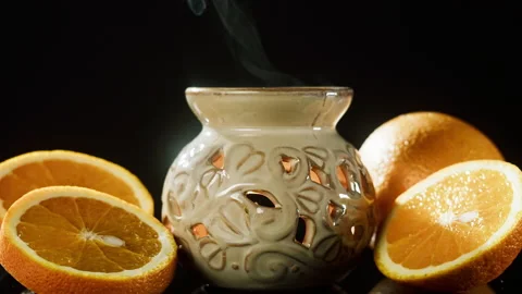 Candle holder and oranges close-up. Making aroma candles, oil diffuser on black Video stock 166536430