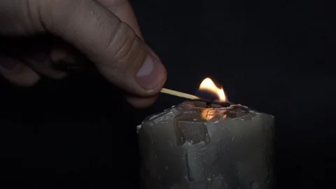 A candle is ignited by a match Stock Footage 99471291