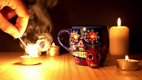 Candle igniting with match by dia de los muertos or day of the dead skull mug Stock Footage 211472032