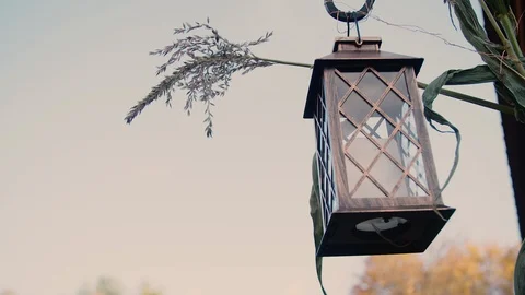 Candle lantern hangs on vine in front of fall season / autumn foliage Stock Footage 119796435