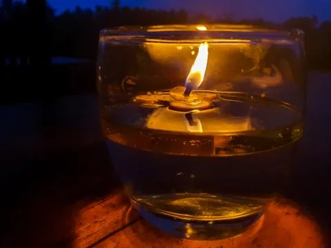 Candle light on dinner table - small beautiful candle light on a glass of wat Foto stock