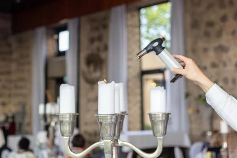 Candle lighting process at a wedding reception in a rustic venue with stone Foto stock