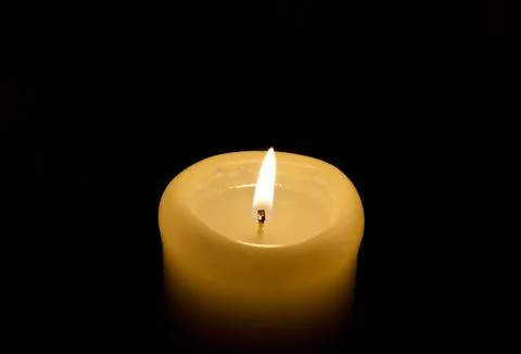 A candle lights up in the darkness Stock Photos