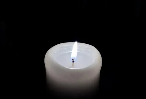 A candle lights up in the darkness Stock Photos