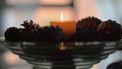 Candle lit on a pine cone tray Stock Footage 73405531